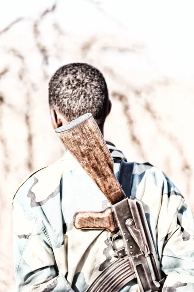 一个黑人士兵和他的枪看着边境 — 图库照片