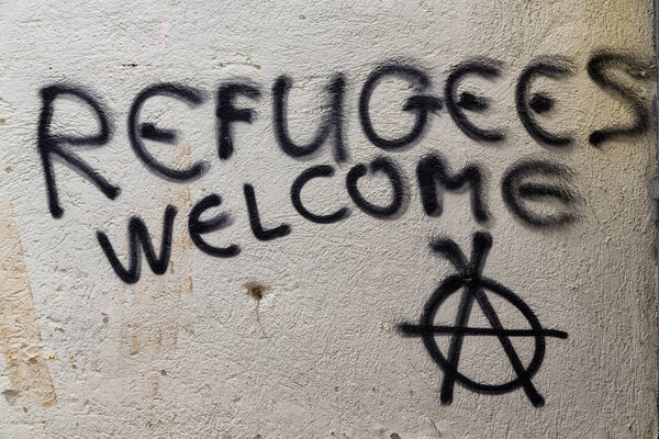 the spray paint in the wall with refugees welcome