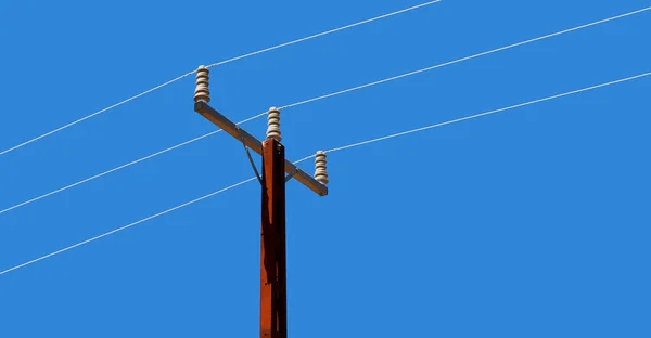 Kabel listrik dengan tiang listrik di langit yang cerah — Stok Foto