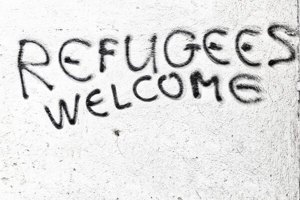 the spray paint in the wall with refugees welcome
