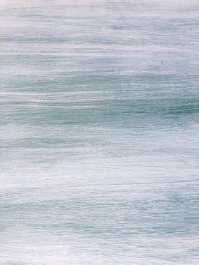 Provence tarzında eski boyanmış ahşap bir kapının pürüzsüz dokusu. Üzerinde çizikler olan beyaz ve mavi tahta. Güzel doğal bir dokusu olan yaşlanmış çam ağacı yüzeyi. Bir ormanın dikey lifleri. Eski