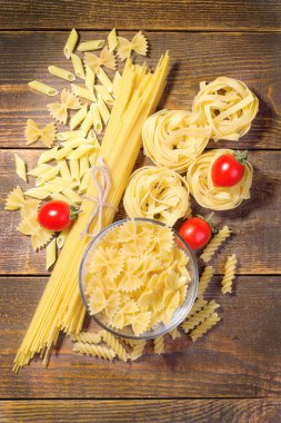 Kiraz domates kahverengi ahşap arka plan üzerinde kuru pasta çeşitleri