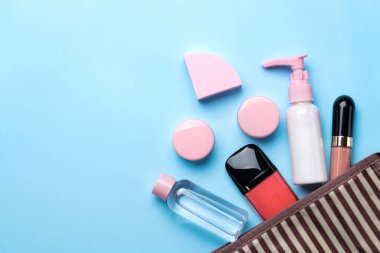 Makyaj. Kozmetik çantada kadın kozmetik ürünleri. Parlak mavi arka planda makyaj malzemeleri. en üstteki görünüm