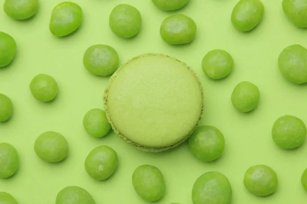 The concept of minimalism. Macaroon cake and tasty bright green sweets on a bright green background. top view