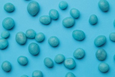 Minimalizm kavramı. Parlak mavi arka plandaki lezzetli parlak mavi şekerlerin arkaplanı. en üstteki görünüm