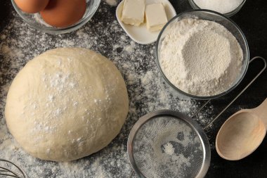 Hamur işi pişirmek için. Lezzetli kurabiyeler yapmak. Hamur, yumurta, un, tereyağı ve şeker için malzemeler koyu arkaplanda.