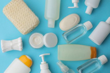 Çeşitli kişisel bakım ürünleri. Yüz kremi, sabun, losyon, pamuk pedler ve mavi bir telefona yapışmış çubuklar. Kaplıca. en üstteki görünüm