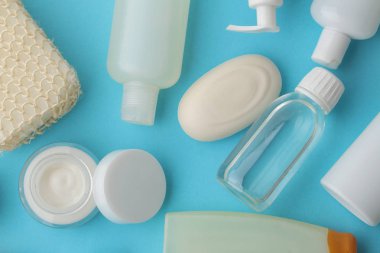 Çeşitli kişisel bakım ürünleri. Yüz kremi, sabun, losyon, pamuk pedler ve mavi bir telefona yapışmış çubuklar. Kaplıca. en üstteki görünüm