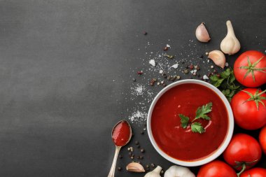 Kırmızı sos ya da ketçap ve yemek, baharat, sarımsak, domates ve siyah arka planda bitkiler için malzemeler. en üstteki görünüm