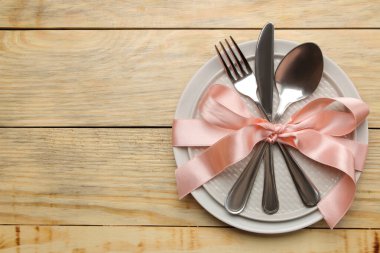 Masa ayarı. Tabak, cam ve çatal, kaşık ve bıçak, doğal ahşap bir masada. en üstteki görünüm