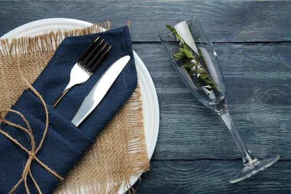 餐桌布置 玻璃器皿和餐具 用蓝色餐巾 叉子和刀叉在蓝色木制桌子上 顶部视图 — 图库照片