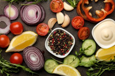 Karanlık bir masada salata ya da diğer yemekleri hazırlamak için dilimlenmiş sebze ve baharatlar. Üst Manzara. Yemek yapmak için malzemeler.