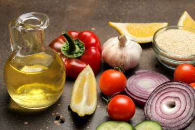 Dilimlenmiş sebze ve baharatlar, salata ya da diğer yemekleri hazırlamak için koyu bir masa üzerinde..