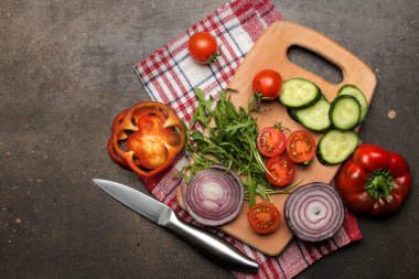 Karanlık bir masada salata ya da diğer yemekleri hazırlamak için dilimlenmiş sebze ve baharatlar. en üstteki görünüm.