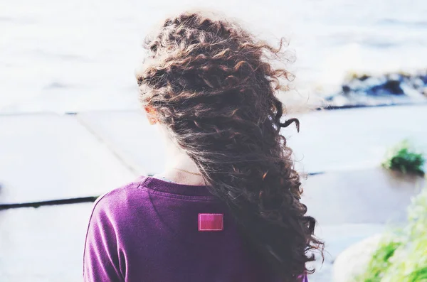 Mulher de cabelo encaracolado escuro na praia Fotografias De Stock Royalty-Free