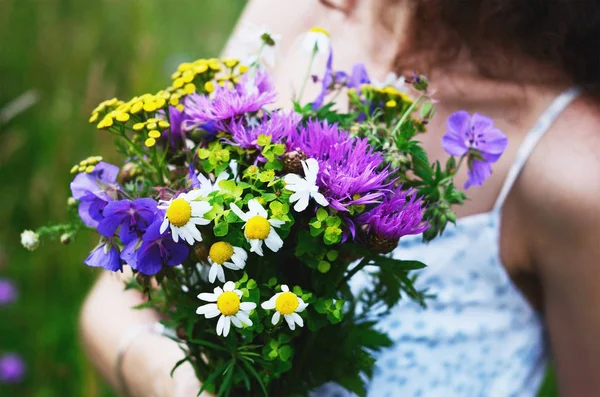 Mädchen mit Strauß bunter Blumen im Sommerfeld — Stockfoto