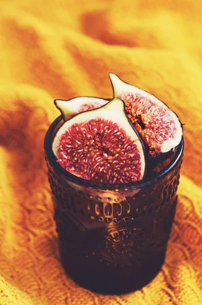 Figos roxos maduros em um copo com espaço de cópia no fundo amarelo — Fotografia de Stock