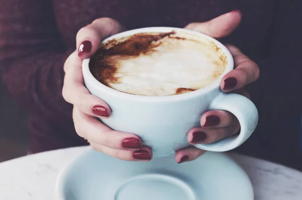 Tasse Morgenkaffee mit Milchschaum in den Händen der Frau — Stockfoto
