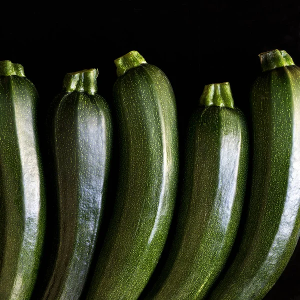 Zucchini (Zucchetti, Zucchini) auf schwarzem Hintergrund Stockbild