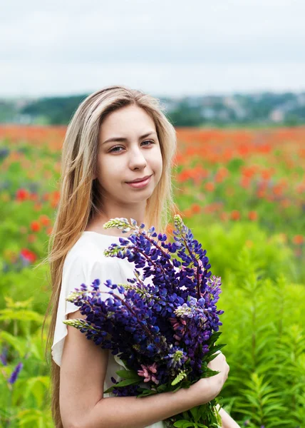 Girl with bouquet of lupine flowers — Stock Photo, Image