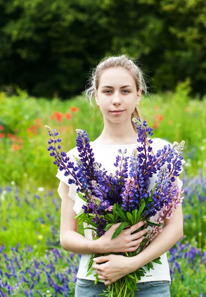 Girl with bouquet of lupine flowers — Stock Photo, Image