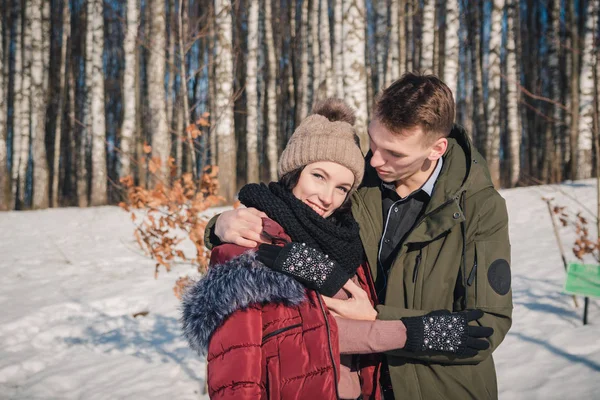 공원에 아름다운 부부가 있습니다 남자가 친구를 껴안고 따뜻하게 해준다 — 스톡 사진
