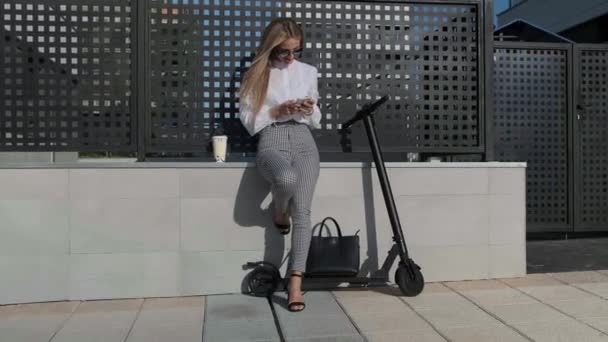 Femme d'affaires avec mobile et son scooter suivant — Video