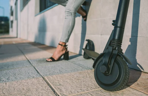 Electric scooter in the street and woman in background. — Stock Photo, Image