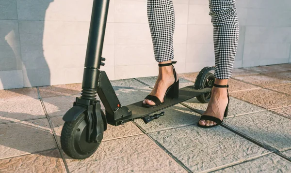 Gambe da donna d'affari irriconoscibili con e-scooter all'aperto — Foto Stock