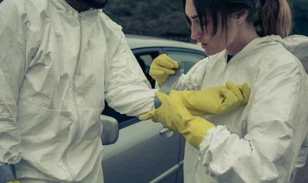 Mujer pegando guantes protectores bacteriológicos a un hombre — Foto de Stock