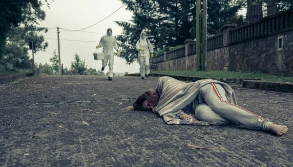 Personas con trajes de protección bacteriológica corriendo para ayudar a una mujer —  Fotos de Stock