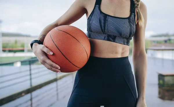 Sportswoman posant avec un ballon de basket — Photo