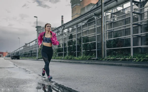 Sportlerin läuft im Industriegebiet — Stockfoto