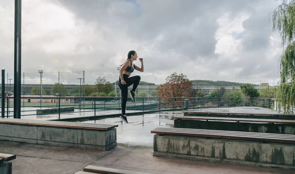 Menina pulando em bancos fazendo treinamento — Fotografia de Stock