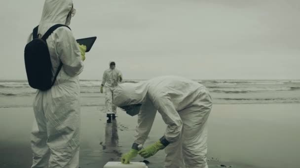 Mensen Met Bacteriologische Beschermingspakken Die Zeewater Het Strand Analyseren — Stockvideo