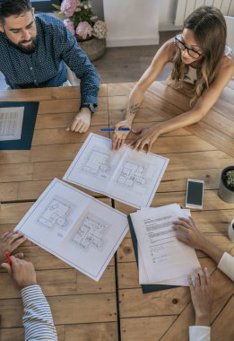 Ofis çalışanları planlara bakmak için toplanıyor.