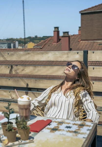 Frau mit Sonnenbrille sonnt sich auf der Terrasse — Stockfoto