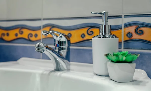 Waschbecken mit Wasserhahn, Seifenspender und Pflanze — Stockfoto