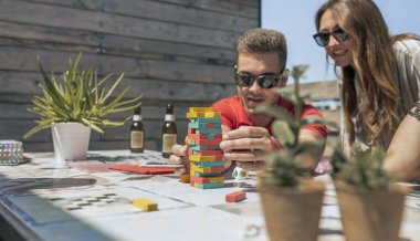 Erkek ve kadın terasta kuleyle oynuyorlar.