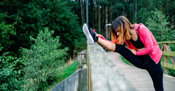 Atleta mujer haciendo estiramiento de pierna —  Fotos de Stock