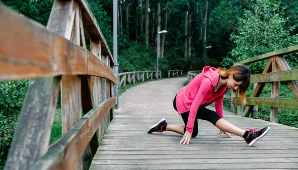 Atleet vrouw doet been stretch — Stockfoto