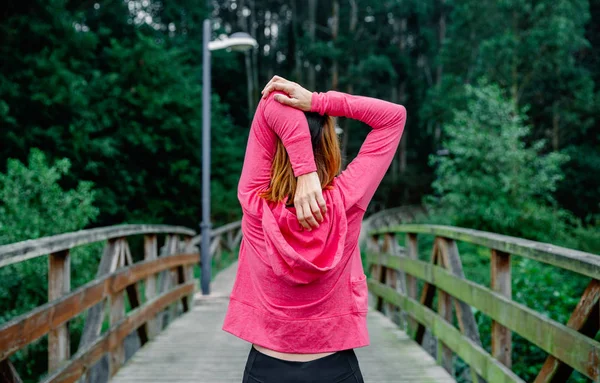 Unrecognizable sportswoman doing stretching arms outdoors — Stock Photo, Image