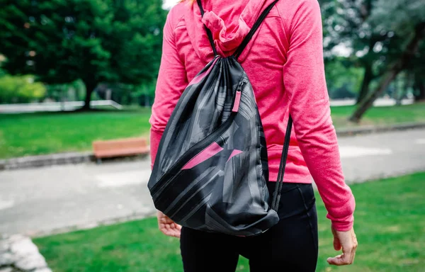 Unrecognizable sportswoman with backpack going to the gym