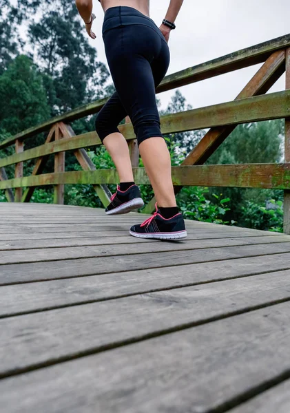 Donna che corre attraverso un parco urbano — Foto Stock