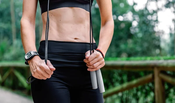 Vrouw poseren met springtouw in een park — Stockfoto