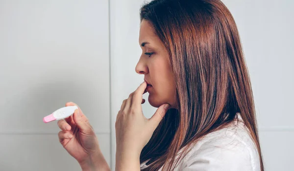 Pregnant looking at a pregnancy test — Stock Photo, Image