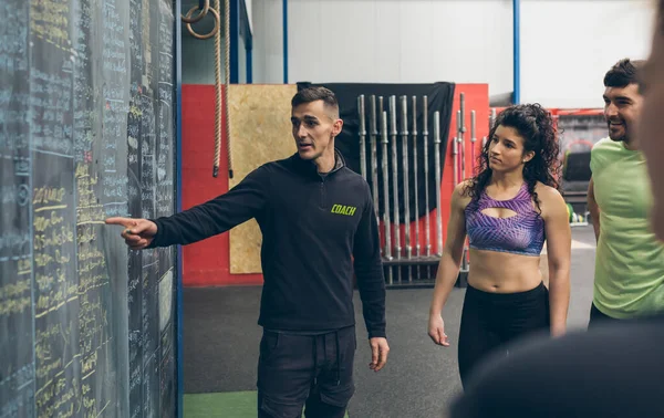 Coach explicando a los atletas en el gimnasio —  Fotos de Stock