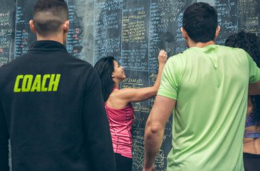 Sporcu kadın jimnastik tahtasına sonuçları yazıyor.