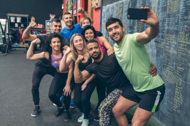 Sporcular spor salonunda cep telefonuyla selfie çekiyorlar.