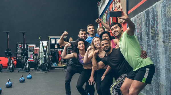 Sportowcy robią sobie selfie z telefonem na siłowni — Zdjęcie stockowe